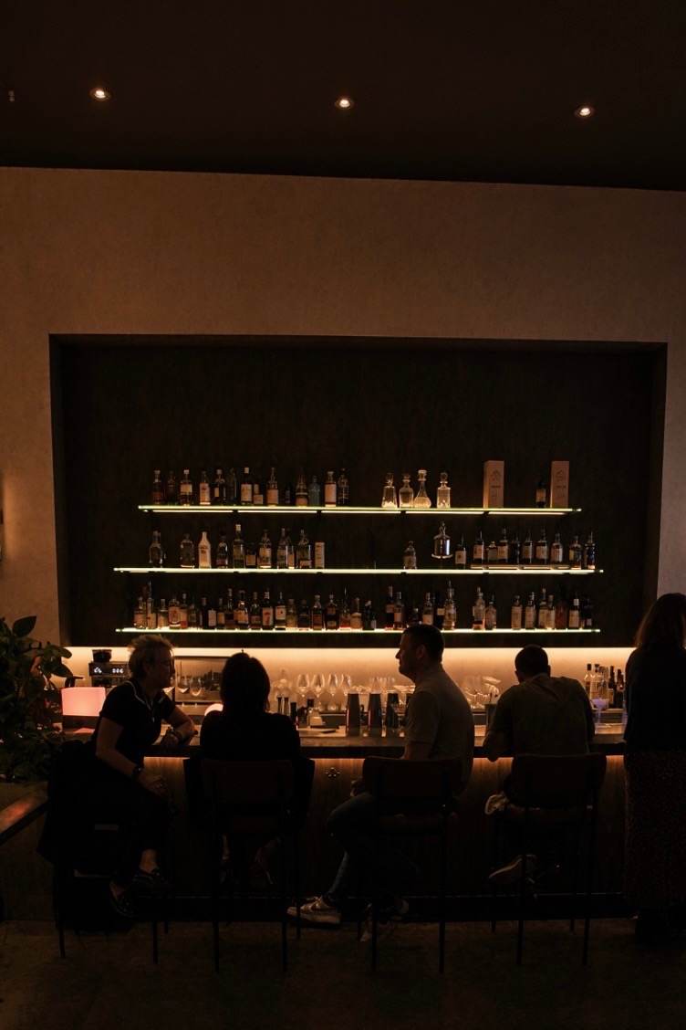 Guests at the backlit bar at night